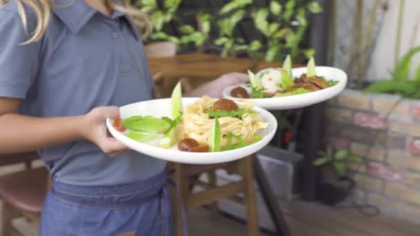 Camarera sirviendo niños pequeños en la mesa del restaurante. Un niño y una niña comiendo en la cafetería. Niños felices comiendo en el restaurante infantil. Nutrición y concepto de alimentación saludable . — Vídeos de Stock