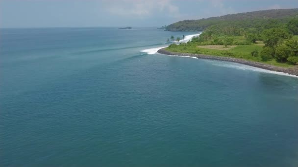 Surferów surfing na deski surfingowej na błękitne fale morskie w tropikalnym wakacje widok z lotu ptaka. Surfing w oceanie Bali Island, Indonezja. Sporty wodne. Sport ekstremalny. Letnie atrakcje. — Wideo stockowe