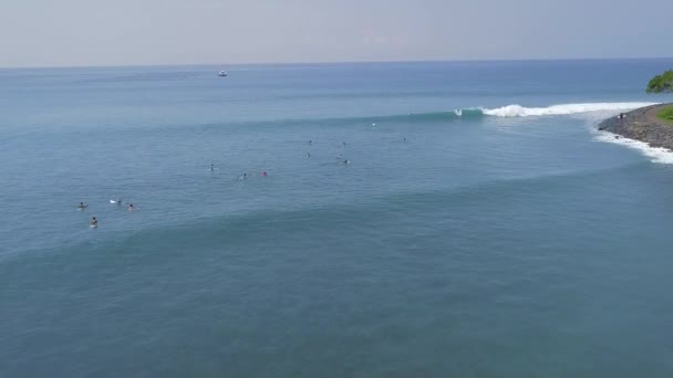 Surfistas surfando na prancha de surf em ondas azuis do mar em férias tropicais vista aérea. Surf na ilha Bali oceano, Indonésia. Desporto aquático. Desporto extremo. Actividades de Verão — Vídeo de Stock