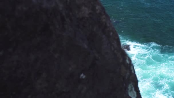 Mocné mořské vlny se rozbíjejí na skalnatý ostrov. Tyrkysové vlny se při bouřce stříkající do kamenitých útesů s pěnou a sprejem. Horský útes a mořská krajina. — Stock video