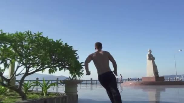 Acrobat practicando parkour salta en la calle urbana. Corredor libre hombre truco de entrenamiento y truco en la ciudad de verano. Estilo de vida juvenil activo. Parkour y freerunning. Deportes extremos al aire libre — Vídeo de stock