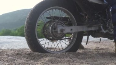 Motosikletçi mtorcycle üzerinde dağlarda kumlu yolda kayma. Yaylalarda kumlu yolda motosikletle araba kullanan turist. Moto seyahati. Motosiklet yaşam tarzı