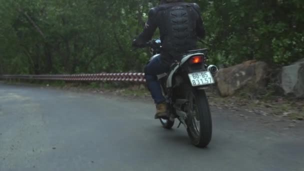 Motorrijder rijden op motorfiets op de weg terwijl Moto Travel. Biker man rijden op motorfiets op het platteland weg. Motorfiets reizen. Moto Lifestyle — Stockvideo