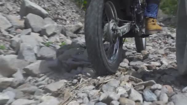 Motorcyclist riding on motorcycle on gravel countryside road. Moto biker driving on motorcycle at rocky off road. Moto sport and travel. Motorcycle lifestyle. — Stock Video