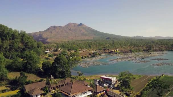 Aerial view of a tropical fishing village lake with a view of volcanic craters. — Stock Video