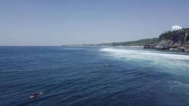 Luchtfoto: Vliegen boven een groep surfers peddelend over de blauwe oceaan in de zomer. — Stockvideo