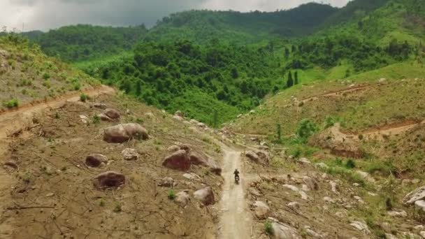 공중: 산 중턱 의작은 흙길을 자동차를 타고 가는 더러운 자전거타는 사람. — 비디오