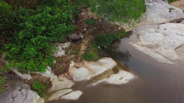 Воздушный кадр мотогонщика за рулем грязного велосипеда на грубой дорожке по реке . — стоковое видео