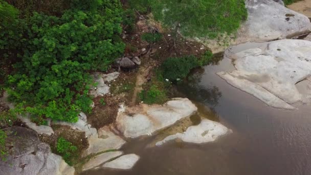 Vue aérienne d'un motocross conduisant un vélo de saleté dans le sentier accidenté de la rivière . — Video