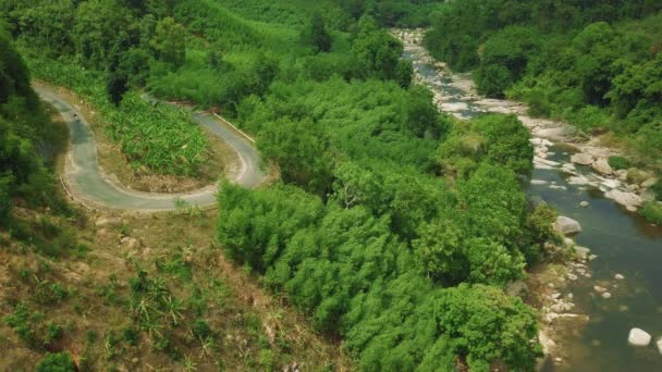 A motorbiker driving on curve rural road in the coutryside near forest river. — Stock Video