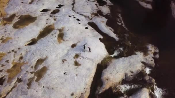 Vista aérea de arriba hacia abajo un hombre conduciendo bicicleta todoterreno en la superficie de piedra en el río . — Vídeos de Stock