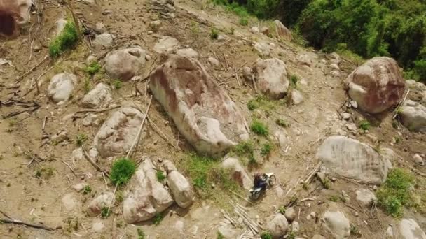 Légi. Extrém lovaglás egy dirt motoros a veszélyes domboldalon nagy sziklák. — Stock videók