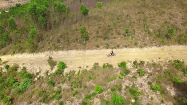 Tracciamento aereo colpo di uomo in bicicletta su strada sterrata in discesa in montagna . — Video Stock