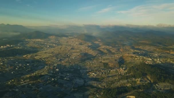 Filmagem aérea cidade cênica na montanha com casas verdes e campos de flores — Vídeo de Stock