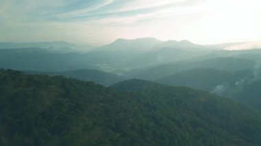 Parlak gökyüzü ve yazları bulutlarla güzel dağ manzarasının üzerinden uçmak
