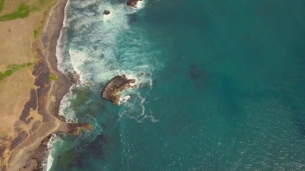 공중 드론으로 바다에 떠 있는 청록색 바닷물 과 해변에 떠 있는 백파를 찍은 장면. — 비디오