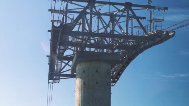 Ein Nahblick auf Seilbahn oder Schwebebahnmast am strahlend blauen Himmel und Meer. — Stockvideo