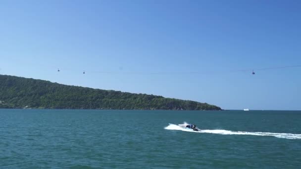 Um barco viajando em velocidade rápida no mar azul para uma ilha tropical no dia ensolarado — Vídeo de Stock