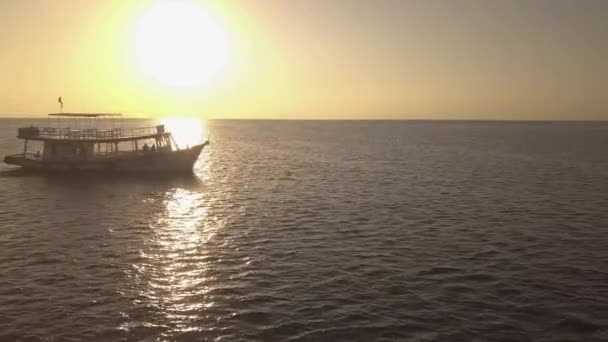 Vista cinematográfica de um barco que navega pelo mar ao nascer do sol . — Vídeo de Stock