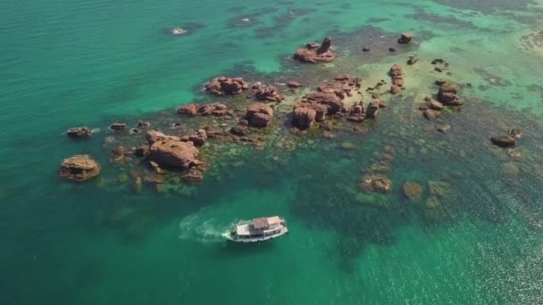 Luftaufnahme der felsigen grünen Lagune mit Boot, das auf dem unberührten Wasser schwimmt. — Stockvideo