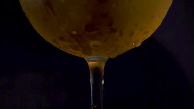 Alkolik içecekler ve yoğuşma damlacıklarıyla bir şarap kadehini yakın çekim yap..