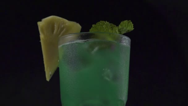 Κοντινό πλάνο του πράσινου τροπικού κοκτέιλ σε γυαλί σε σκούρο φόντο. — Αρχείο Βίντεο