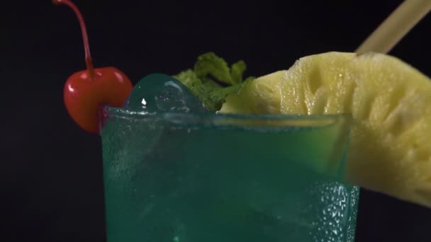 A glass green cocktail drink rotating on black background. Close up shot. — Stock Video