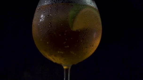 Кінематографічний похилий знімок склянки алкогольного напою на темному фоні . — стокове відео