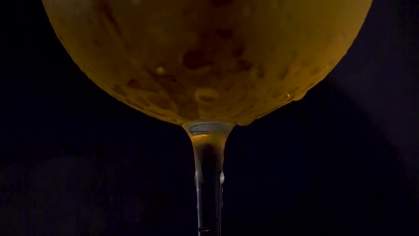 Närbild skott på ett vinglas med alkoholhaltiga drycker och kondensdroppar. — Stockvideo