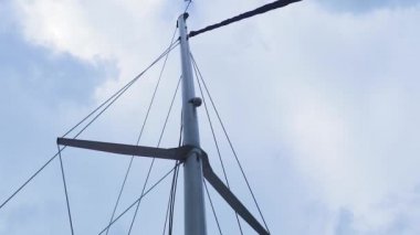 Okyanusta yüzen bir yelkenlinin direği Parlak bulutlara ve gökyüzüne karşı.