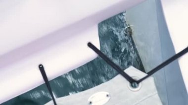 Okyanusta giden bir yelkenlinin altından su sıçrıyor..