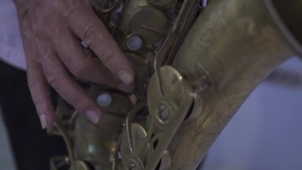 Vista de cerca de una mano de hombre tocando un saxofón viejo. — Vídeos de Stock