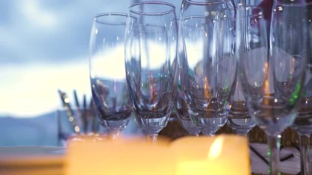 Vista de cerca de copas de vino vacías en la mesa con velas encendidas. — Vídeos de Stock