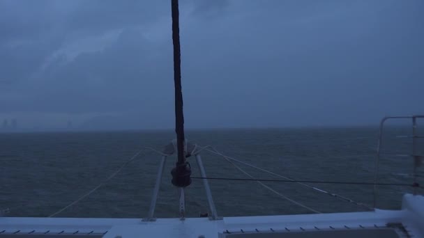 Kasvetli bir havada, karanlık ufukta, denizde seyahat eden bir yelkenli.. — Stok video