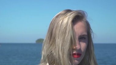 Kırmızı ruj süren kendinden emin ve güzel genç bir kadının portresi..