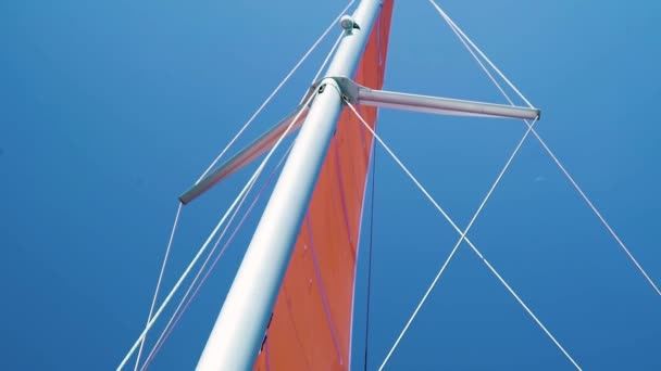 Lower angle view of a mast and mainsail with ropes of a sailing boat. — Stock Video