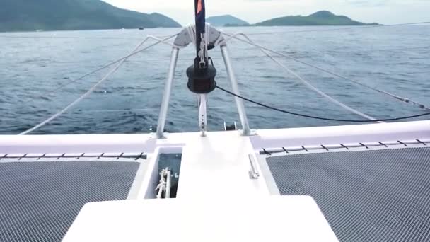 Däck utsikt över resor vit yacht rör sig i det blå havet mot en ö. — Stockvideo