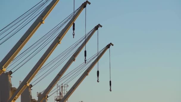 Närbild av en rad av last port kran mot klarblå himmel. — Stockvideo