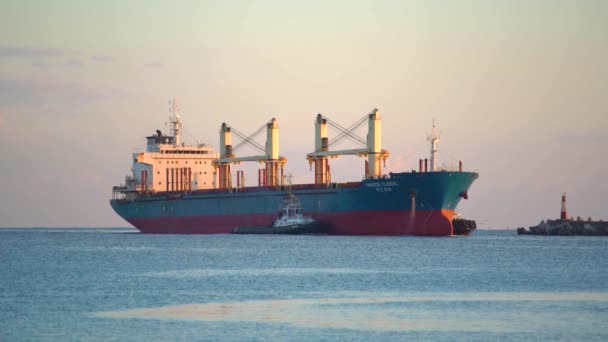 Egy hatalmas teherhajó közeledik a tengerhez egy tengeri kikötő felé.. — Stock videók