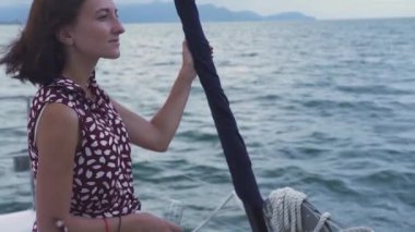 Genç kaygısız kadın bir yatın güvertesinde okyanus manzarasının tadını çıkarıyor..