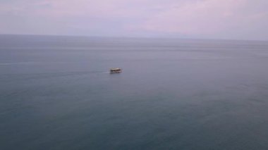 Gezgin bir turist teknesiyle huzurlu bir okyanusun üzerindeki sinematik hava manzarası..