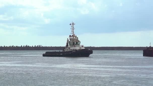 Um barco de patrulha navegando no mar se aproximando em direção a um porto de carga . — Vídeo de Stock