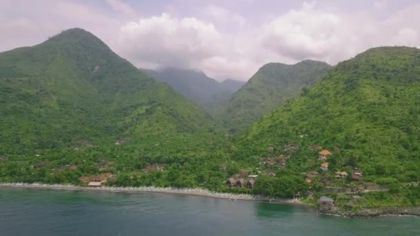 Naturskön utsikt över byn i bergen täckt med grönskande grönska nära havet. — Stockvideo