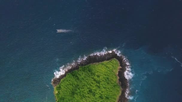 Vista aérea incrível sobre o oceano azul com ilhota verde e barco . — Vídeo de Stock