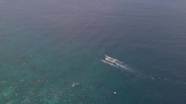 Sakin okyanusta hızla seyahat eden bir turist teknesinin hava aracı görüntüsü..