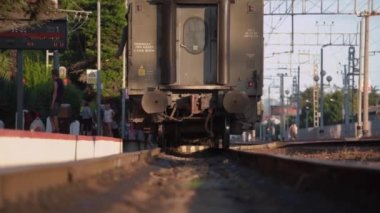 Demiryolu boyunca, kaldırımlı istasyon platformunu geçerek geri tren sürücüleri