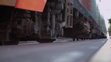 Elektrikli yolcu treni platformdan geçen raylarda hareket ediyor.