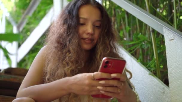 Koncentrált hölgy hosszú göndör haj néz okostelefon — Stock videók