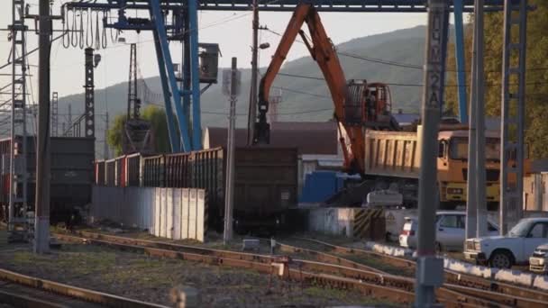 Žlutý jeřáb s kovovou sběrnicí vyloží železniční nákladní dopravu — Stock video