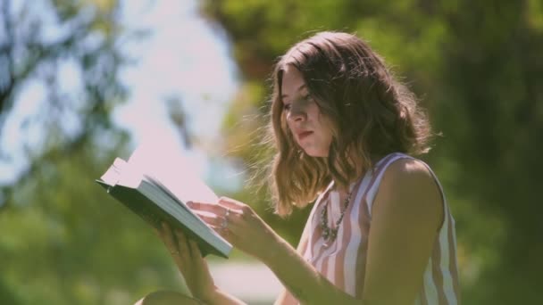 Senhora concentrada com cabelo encaracolado vira páginas de livro branco — Vídeo de Stock